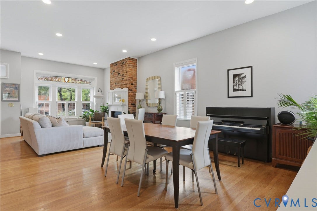 404 N Shields Avenue, Richmond, VA 23220 Open-concept living space featuring wood-finish flooring, recessed lighting, and a brick accent wall with a fireplace