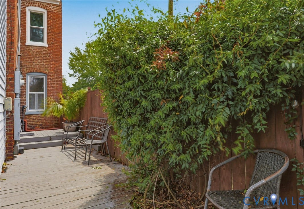 404 N Shields Avenue, Richmond, VA 23220 Outdoor deck area featuring wood-finish decking, a brick exterior wall, and privacy fencing with established greenery