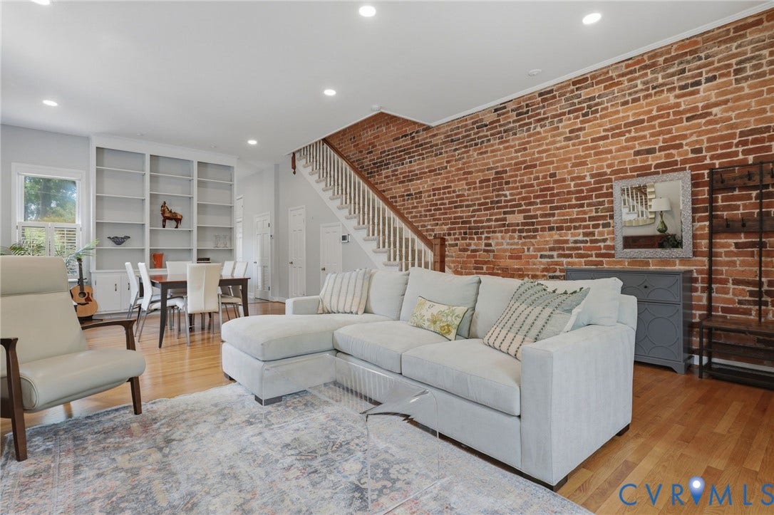 404 N Shields Avenue, Richmond, VA 23220 Exposed brick accent wall and hardwood flooring characterize this living area