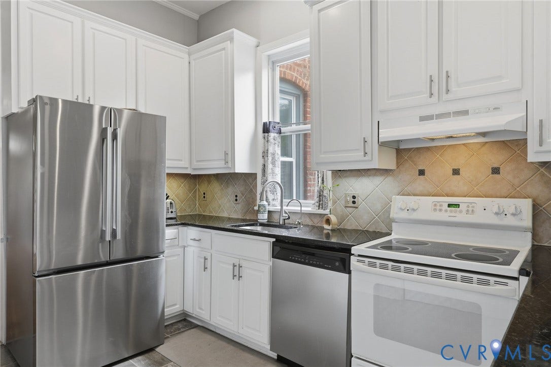 404 N Shields Avenue, Richmond, VA 23220 Kitchen featuring white cabinetry, black stone countertops, stainless steel refrigerator, stainless steel dishwasher, and tiled backsplash
