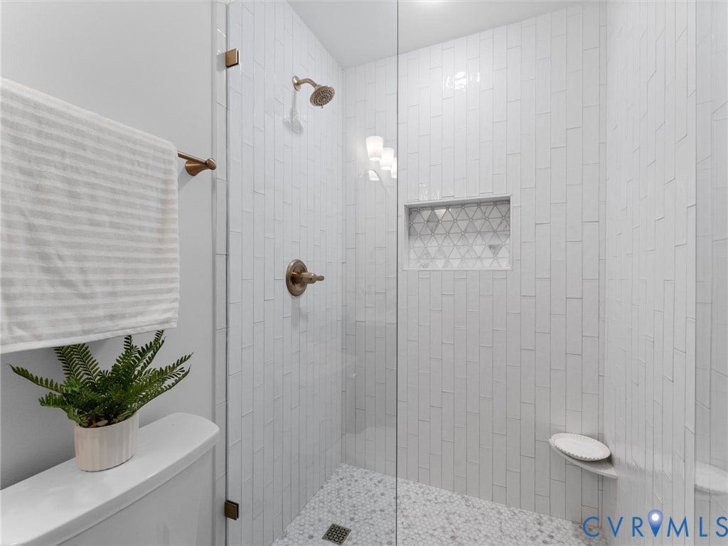 10400 Claybar Trail, Chesterfield, VA 23236 Contemporary shower enclosure featuring clear glass panels, vertical subway tile, and a mosaic tile niche