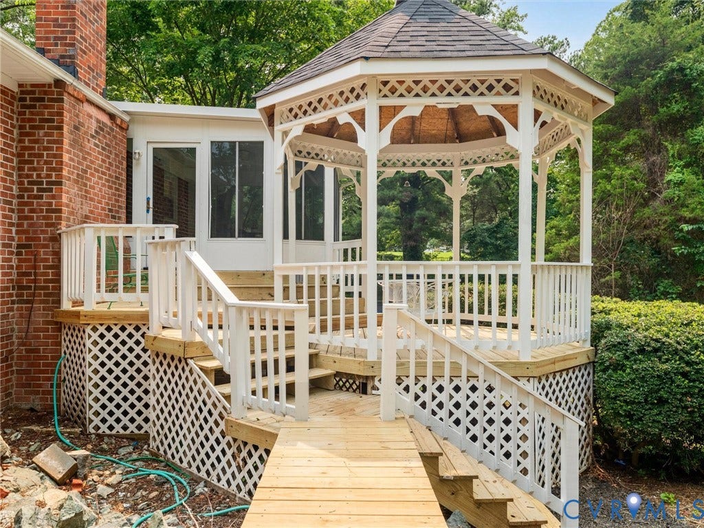 10400 Claybar Trail, Chesterfield, VA 23236 Exterior deck with white lattice skirting, featuring a built-in gazebo with a shingled roof, a ramp, and stairs leading to a screened-in porch
