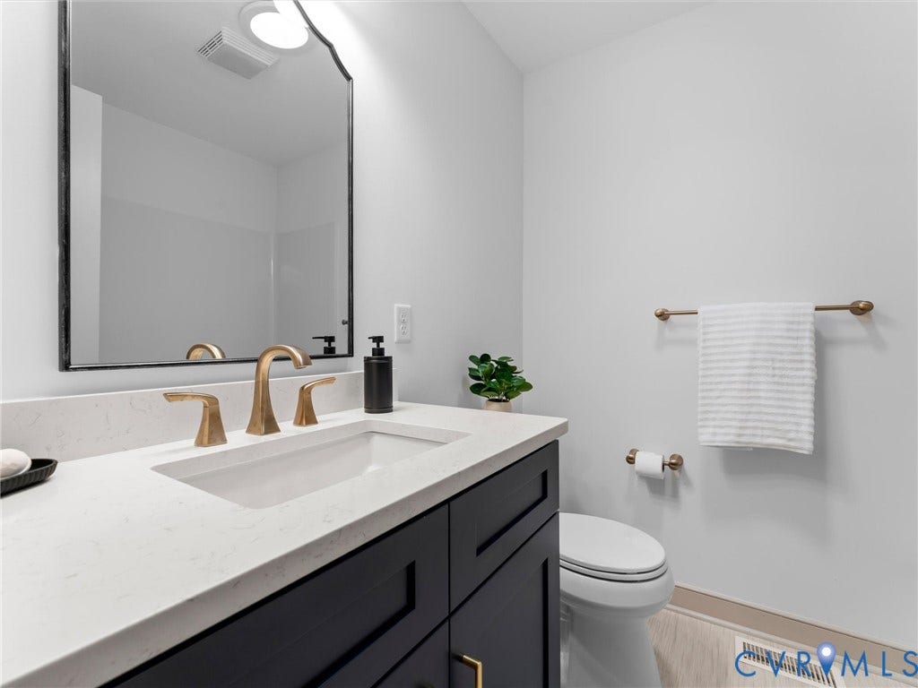 10400 Claybar Trail, Chesterfield, VA 23236 Bathroom featuring a dark wood-finish vanity with a light-toned countertop, an undermount sink, and brass-finish fixtures