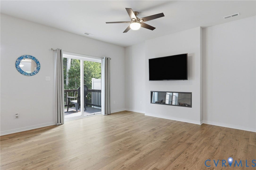 6544 Bolles Landing Court, Chester, VA 23831 Open-concept room featuring wood-finish flooring, a ceiling fan with integrated lighting, and a linear electric fireplace