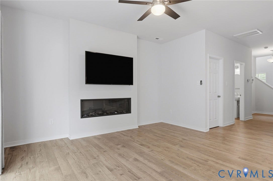 6544 Bolles Landing Court, Chester, VA 23831 Living space featuring wood-finish flooring, a contemporary fireplace, and a wall-mounted television