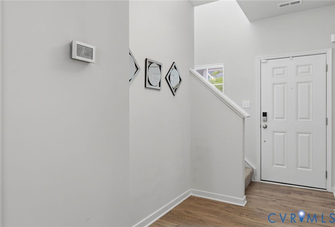 6544 Bolles Landing Court, Chester, VA 23831 Entryway featuring a paneled door with smart lock, wood-finish flooring, a carpeted staircase, and an upper window