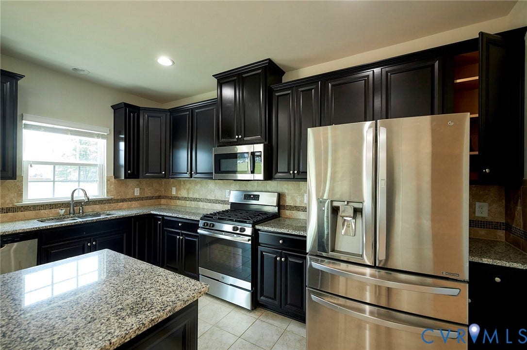 4535 Paxton Glen Court, 3W120, Glen Allen, VA 23059 Kitchen featuring stainless steel appliances, dark wood cabinetry, granite countertops, and tile flooring