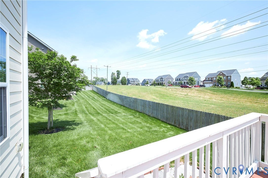 4535 Paxton Glen Court, 3W120, Glen Allen, VA 23059 Expansive green space featuring a wooden privacy fence and a mature tree