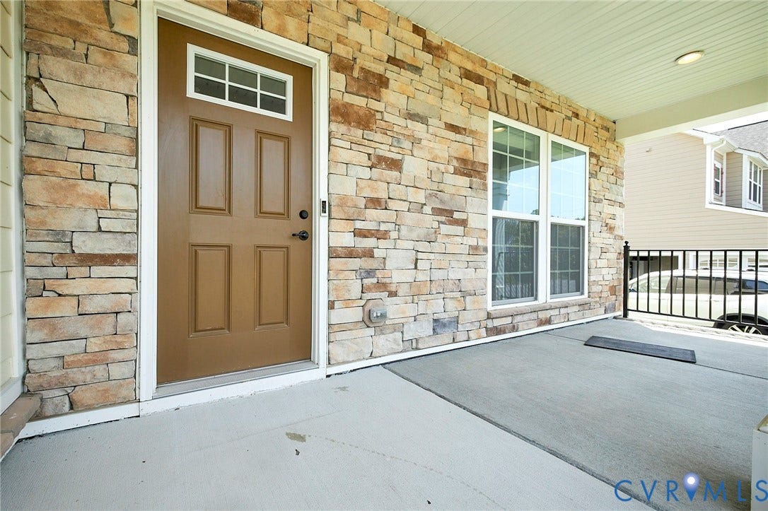 4535 Paxton Glen Court, 3W120, Glen Allen, VA 23059 Inviting front porch featuring a stacked stone facade, paneled entry door with transom window, and a concrete patio