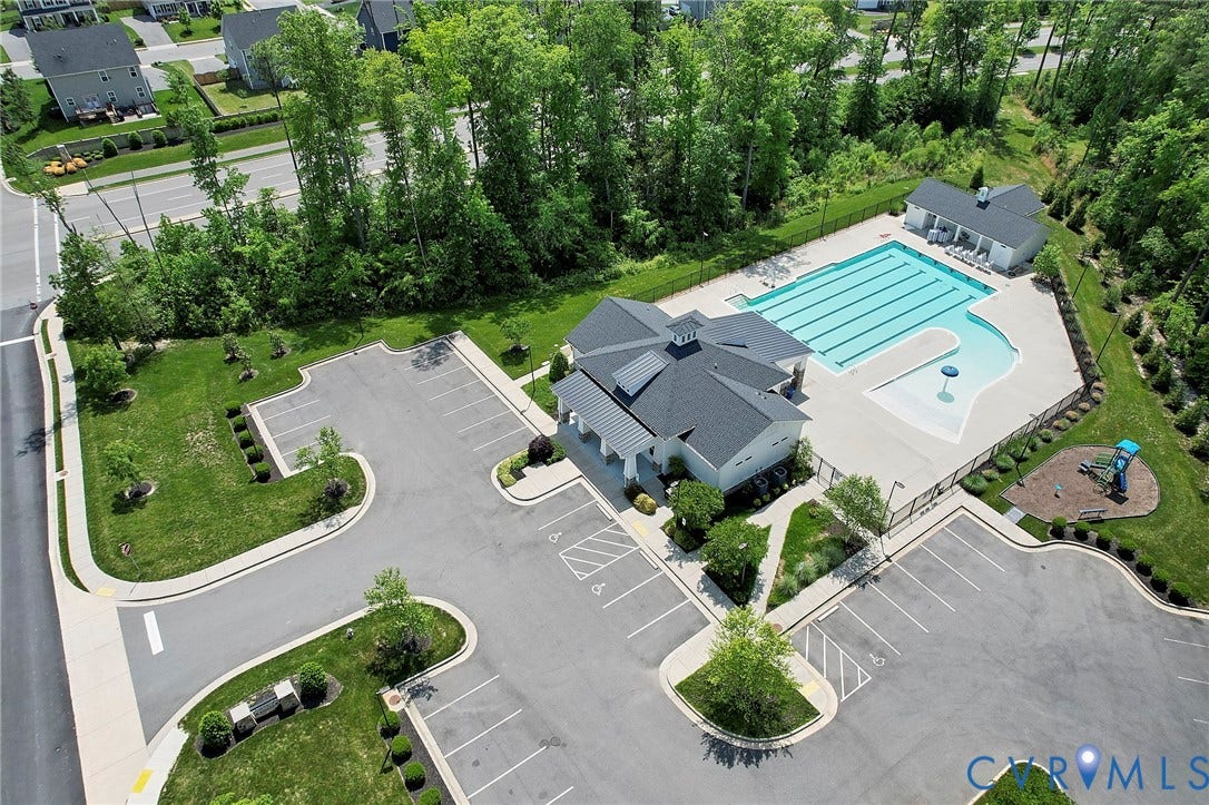 4535 Paxton Glen Court, 3W120, Glen Allen, VA 23059 Community amenities featuring a central clubhouse, an expansive swimming pool with lap lanes, a dedicated splash area, a fenced playground, and a large paved parking area