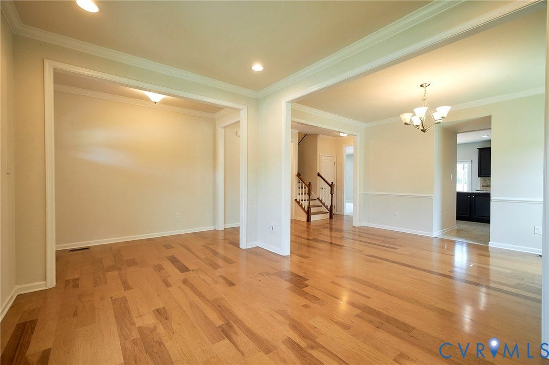 4535 Paxton Glen Court, 3W120, Glen Allen, VA 23059 Expansive open-concept interior featuring light wood-finish flooring, white crown molding, and wainscoting