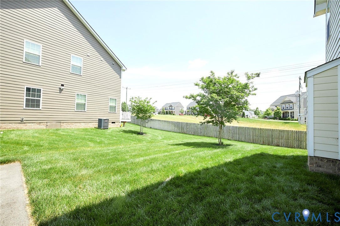 4535 Paxton Glen Court, 3W120, Glen Allen, VA 23059 Expansive grassy yard area with a wood privacy fence and established trees