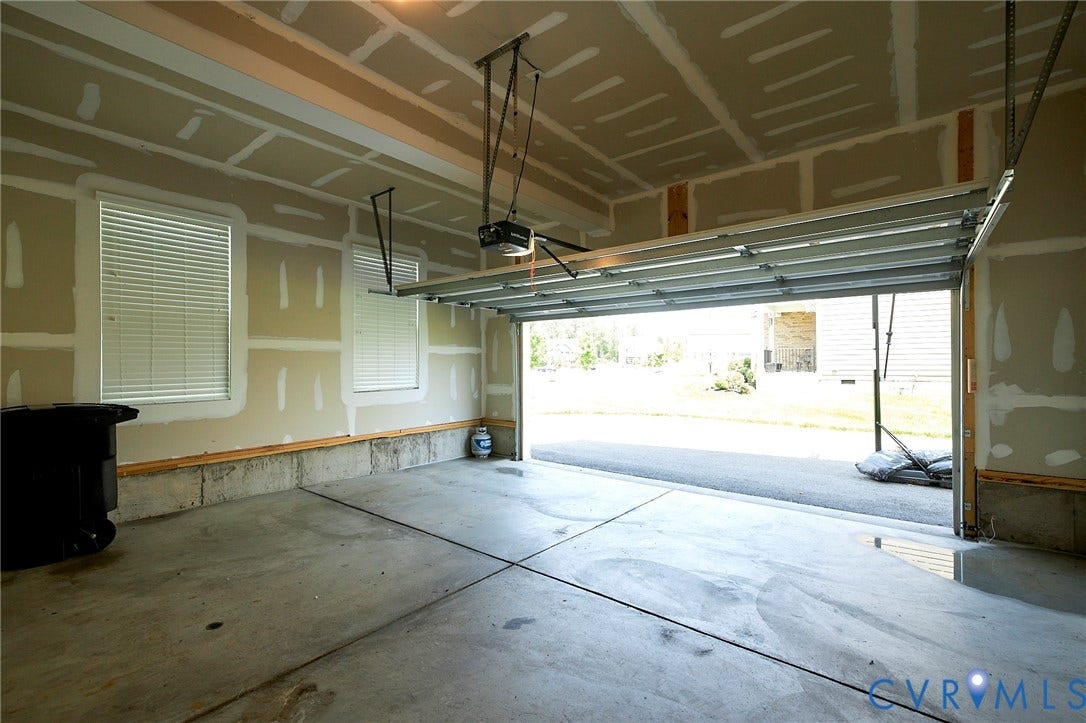 4535 Paxton Glen Court, 3W120, Glen Allen, VA 23059 Attached garage featuring an automatic overhead door, concrete flooring, and two windows with blinds