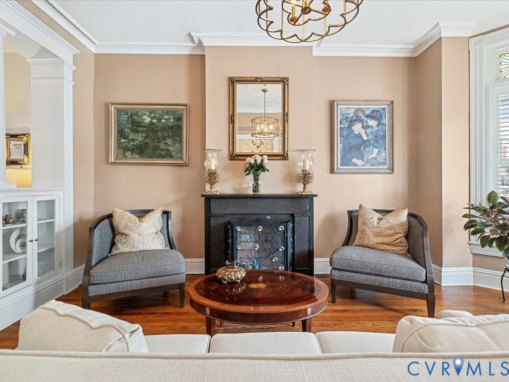 3108 E Broad Street, St John's Historic, Richmond, VA 23223 Living area featuring a black fireplace with an ornate screen, bordered by two upholstered armchairs