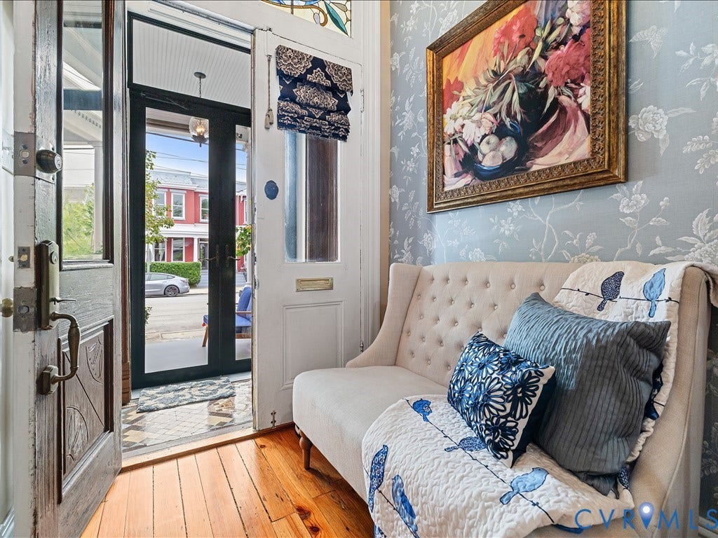 3108 E Broad Street, St John's Historic, Richmond, VA 23223 Entryway featuring hardwood flooring, light blue floral wallpaper, a stained glass transom, and a solid wood entry door