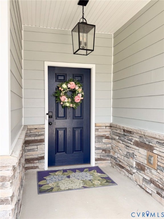10508 Goosecross Way, Stag's Leap/ Stag's Trail, Hanover, VA 23116 Entryway featuring a paneled navy door, stone veneer detailing, horizontal siding, a beadboard ceiling, and an overhead lantern fixture