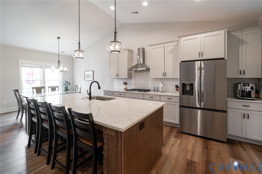 10508 Goosecross Way, Stag's Leap/ Stag's Trail, Hanover, VA 23116 Spacious kitchen featuring a large central island with integrated sink, stainless steel appliances, light cabinetry, and wood-finish flooring