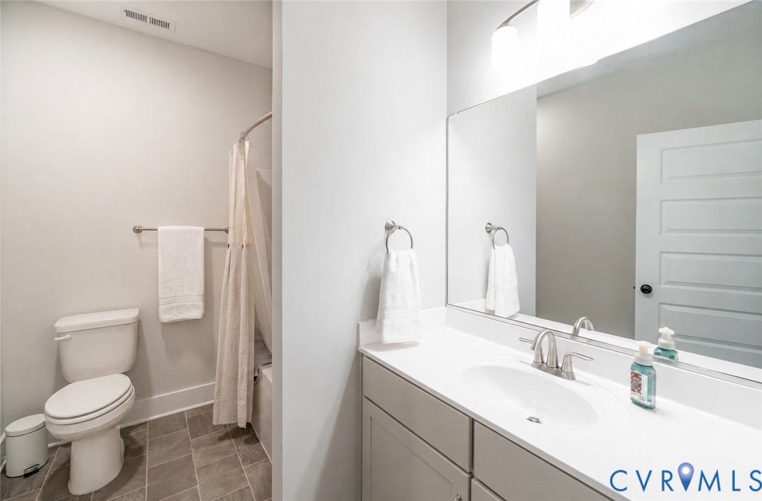 10508 Goosecross Way, Stag's Leap/ Stag's Trail, Hanover, VA 23116 Downstairs hall bathroom featuring a white vanity with an integrated sink, brushed nickel faucet, and a large mirror