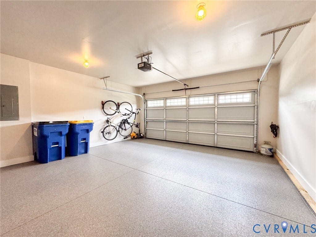 10508 Goosecross Way, Stag's Leap/ Stag's Trail, Hanover, VA 23116 Spacious garage featuring a light gray epoxy floor coating, white walls, and a sectional garage door with frosted transom windows