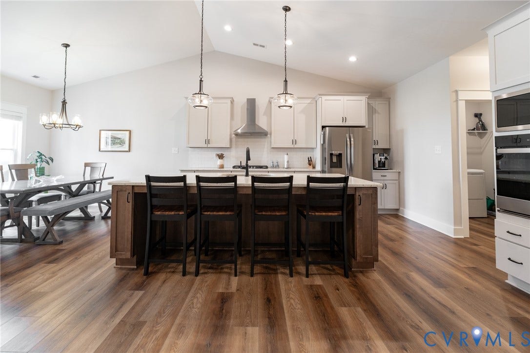 10508 Goosecross Way, Stag's Leap/ Stag's Trail, Hanover, VA 23116 Kitchen featuring a large island with seating, stainless steel appliances, white cabinetry, and wood-finish flooring