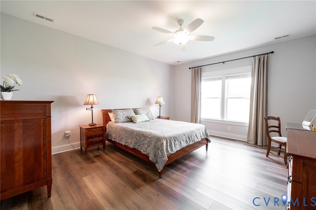 10508 Goosecross Way, Stag's Leap/ Stag's Trail, Hanover, VA 23116 Spacious room featuring wood-finish flooring, a contemporary ceiling fan, and large windows with neutral drapes