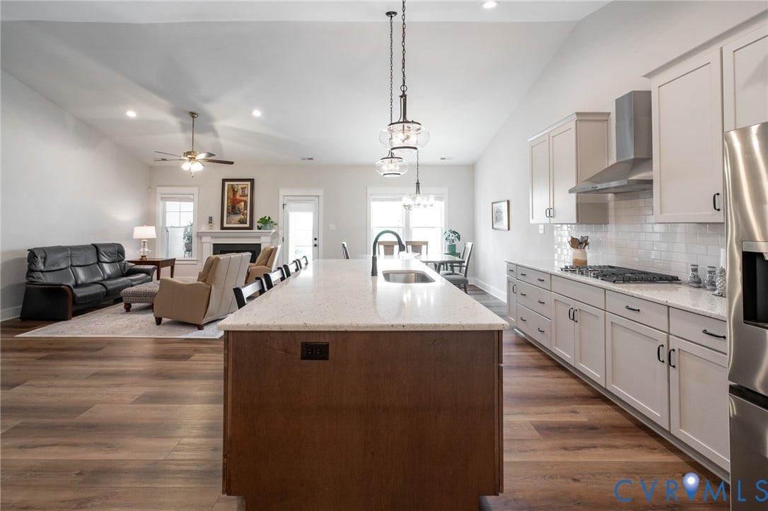 10508 Goosecross Way, Stag's Leap/ Stag's Trail, Hanover, VA 23116 Open-concept kitchen featuring an oversized island with pendant lighting, light-toned cabinetry, stainless steel appliances, and a subway tile backsplash