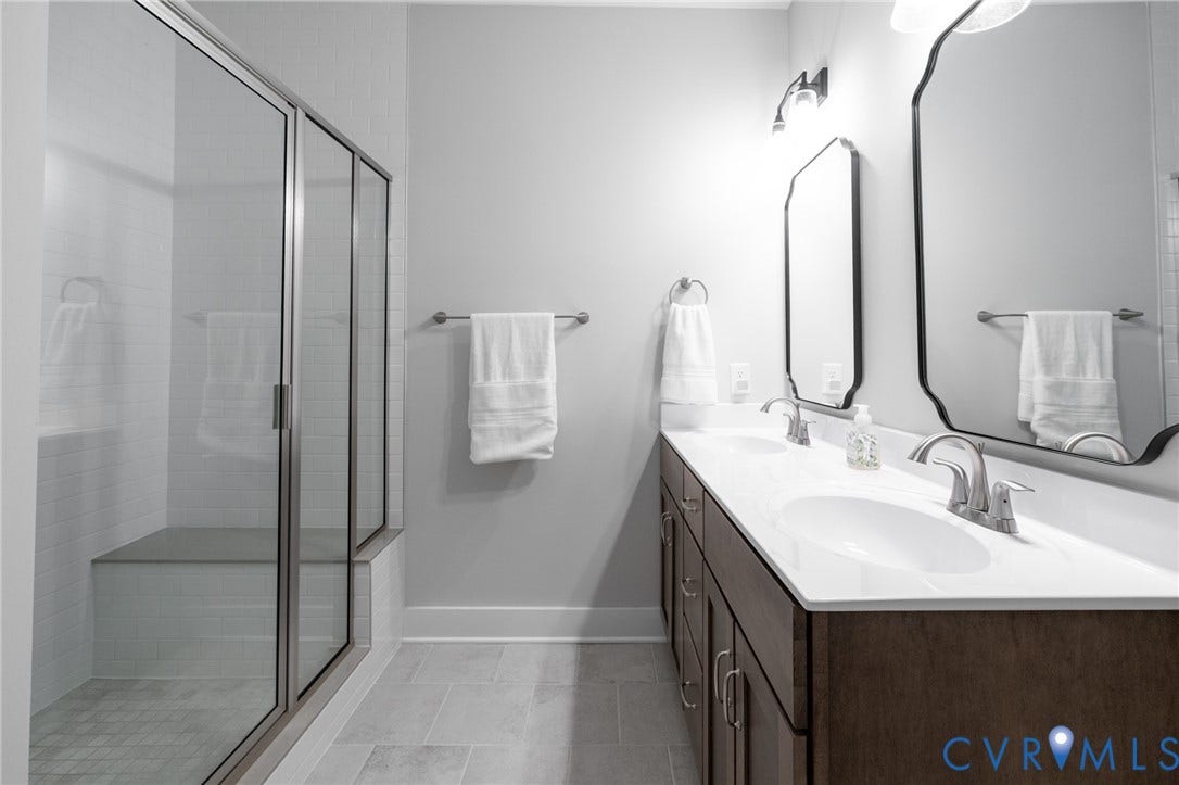 10508 Goosecross Way, Stag's Leap/ Stag's Trail, Hanover, VA 23116 Spacious bathroom featuring a dual vanity with white countertops, a walk-in shower with a built-in bench, and rectangular tile flooring