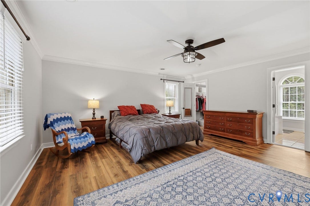 12124 Glen Kilchurn Drive, Chesterfield, VA 23838 Spacious bedroom featuring wood-finish flooring, two windows with blinds, crown molding, and a ceiling fan with integrated lighting