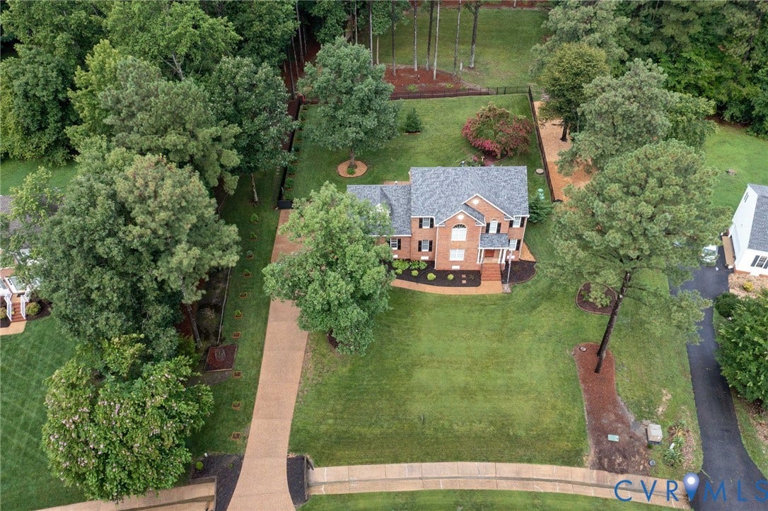 12124 Glen Kilchurn Drive, Chesterfield, VA 23838 Brick residence with a prominent front facade, a paved driveway, mature trees, a fenced rear yard, and established landscaping