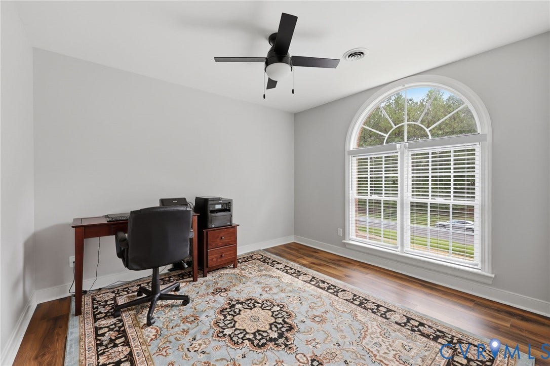 12124 Glen Kilchurn Drive, Chesterfield, VA 23838 Room featuring a large arched window with white blinds, wood-finish flooring, light gray wall paint, and a black ceiling fan with an integrated light fixture
