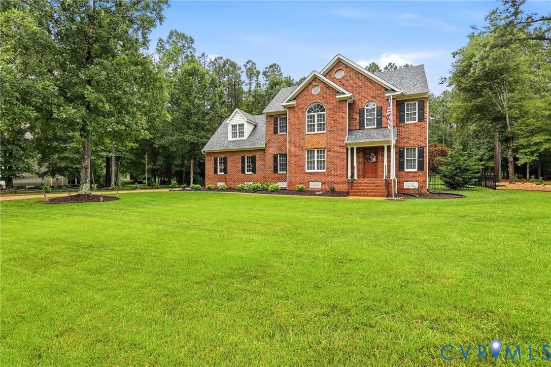 12124 Glen Kilchurn Drive, Chesterfield, VA 23838 Brick Colonial-style residence featuring a prominent arched window, dormer windows, and dark shutters