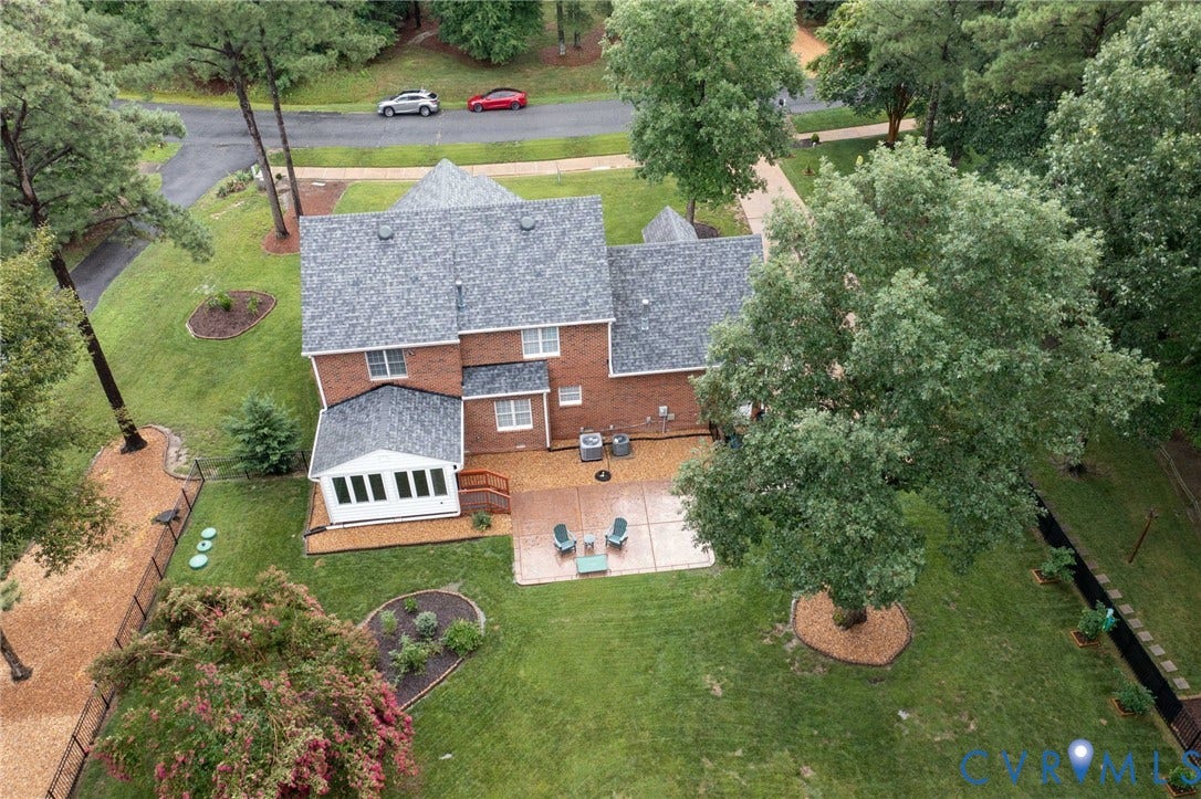 12124 Glen Kilchurn Drive, Chesterfield, VA 23838 Expansive rear yard featuring a manicured lawn, mature trees, and a red brick exterior