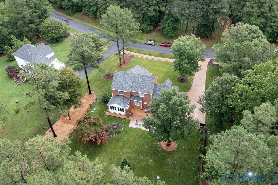 12124 Glen Kilchurn Drive, Chesterfield, VA 23838 Brick facade residence with a multi-gabled roofline, featuring an expansive rear deck, a dedicated sunroom, and a paved driveway