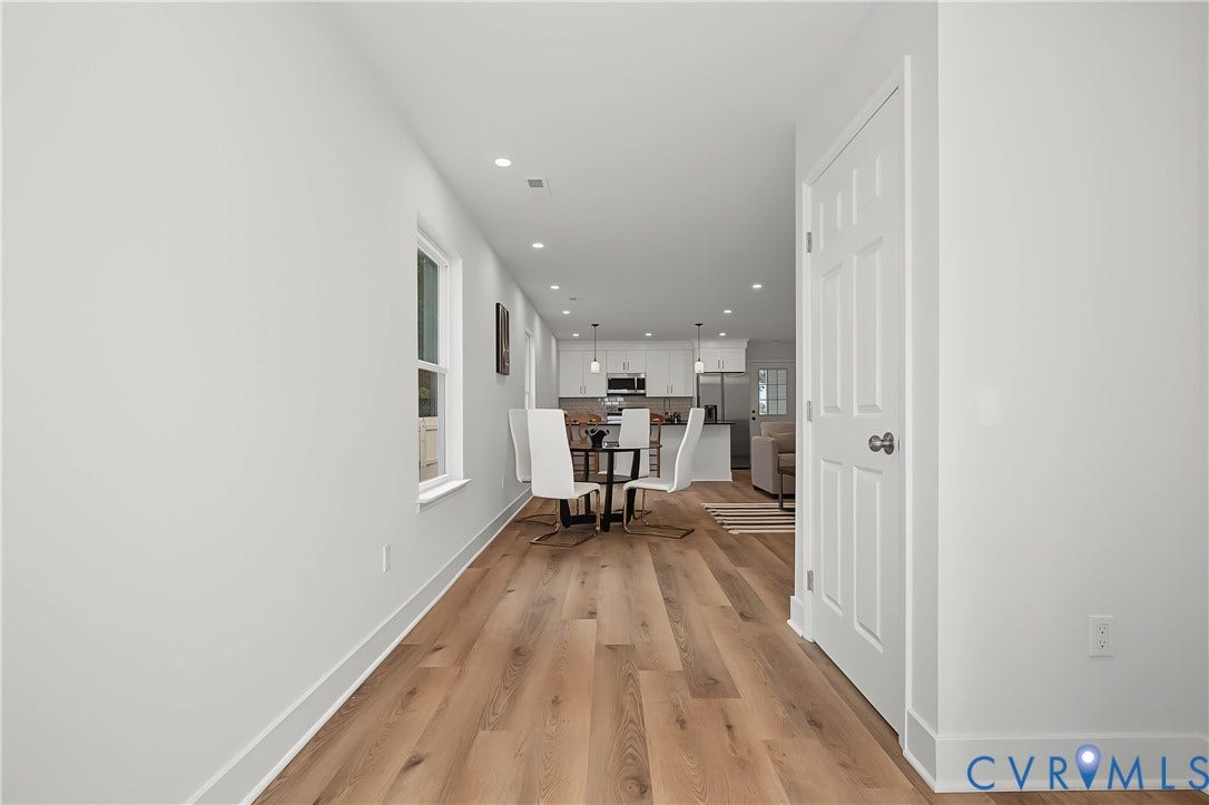 Hallway with wood-finish flooring, white trim, and recessed lighting
