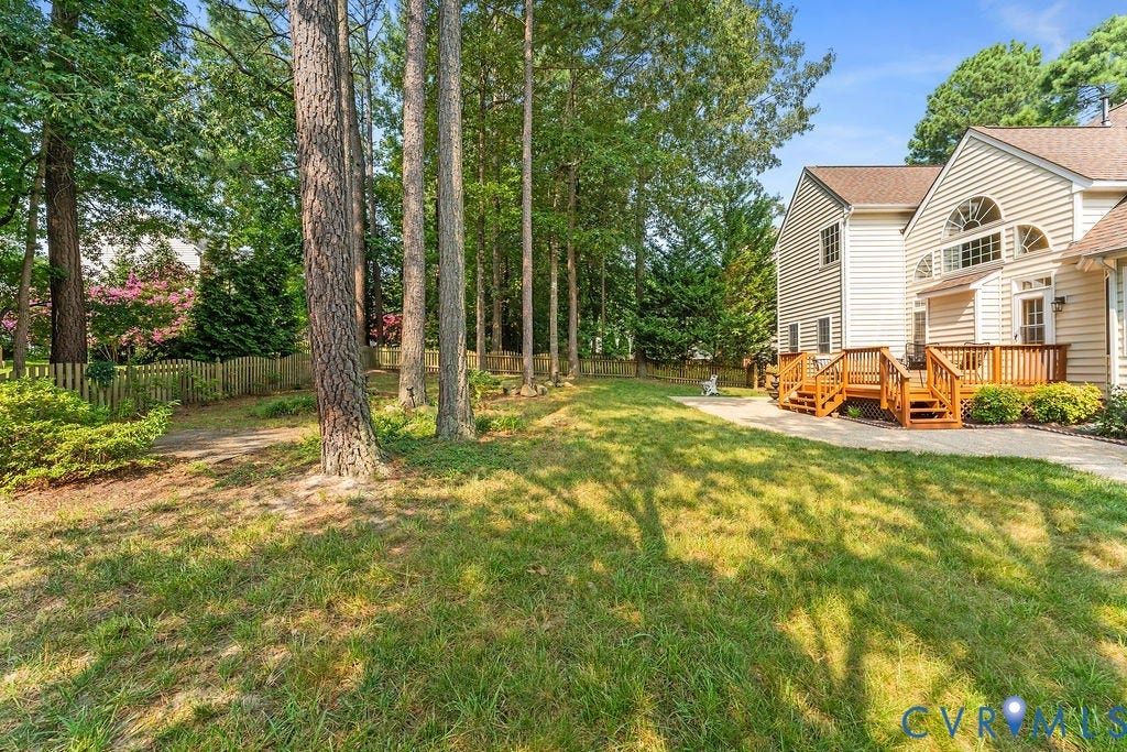 5316 Lemoore Drive, Glen Allen, VA 23059 Expansive rear yard featuring mature trees, a wooden fence, and a multi-level wood deck with steps
