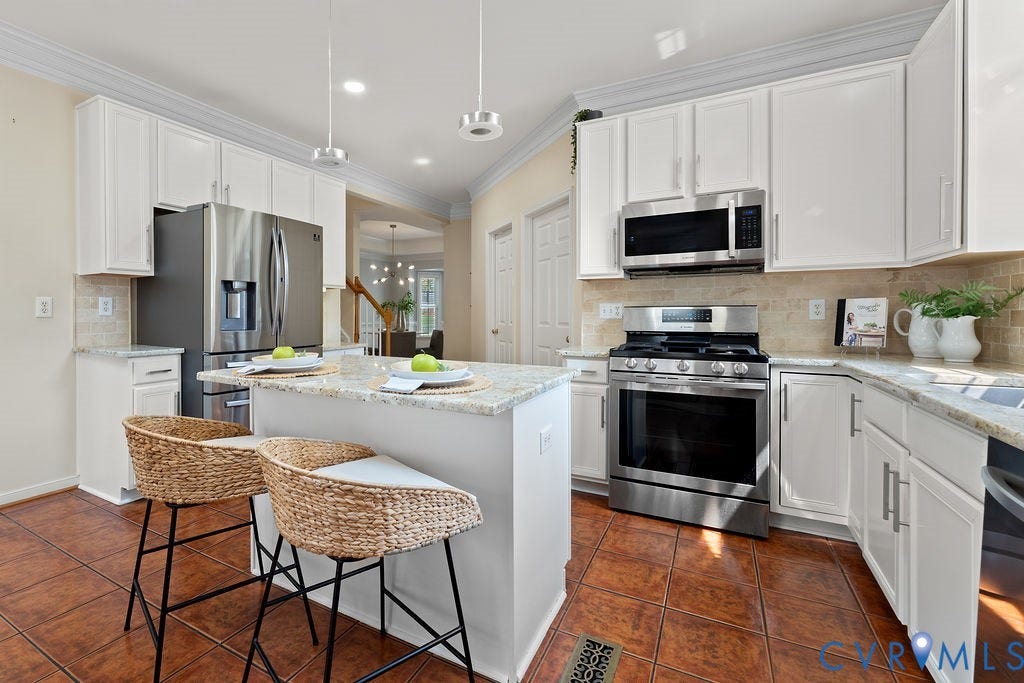 5316 Lemoore Drive, Glen Allen, VA 23059 Kitchen featuring an island with seating, stainless steel appliances, white cabinetry, light-toned countertops, and tile flooring