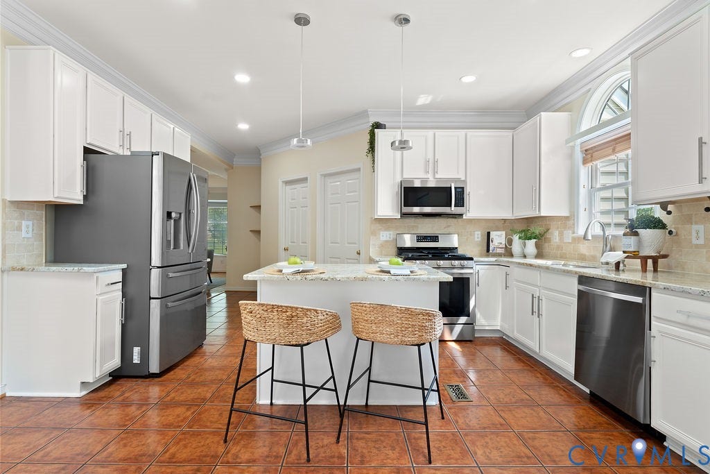 5316 Lemoore Drive, Glen Allen, VA 23059 Bright kitchen featuring white cabinetry, stone countertops, stainless steel appliances, a center island with pendant lighting, and terracotta-style tile flooring