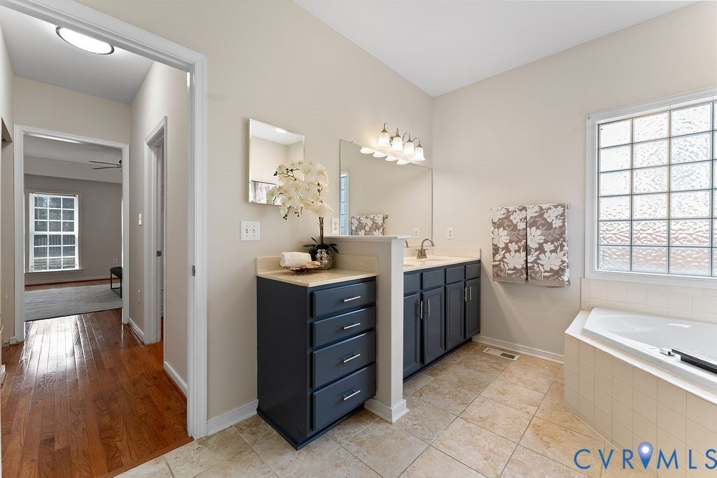 5316 Lemoore Drive, Glen Allen, VA 23059 Bathroom featuring a dual vanity, built-in storage cabinet, and an integrated tub