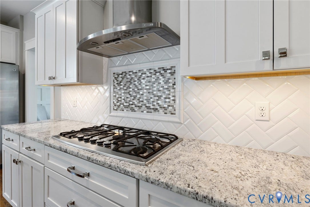 15918 Drumone Road, Hallsley, Midlothian, VA 23112 Kitchen featuring white shaker cabinetry, speckled countertops, a gas range with stainless steel hood, and a white herringbone tile backsplash with mosaic accent