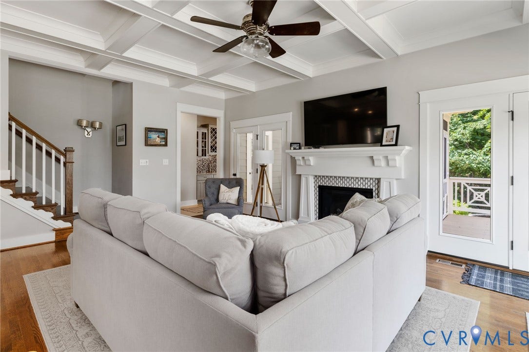 15918 Drumone Road, Hallsley, Midlothian, VA 23112 Living area featuring a coffered ceiling, hardwood flooring, a fireplace with a decorative tile surround and white mantel, a ceiling fan, and a glass-paneled door opening to an outdoor space