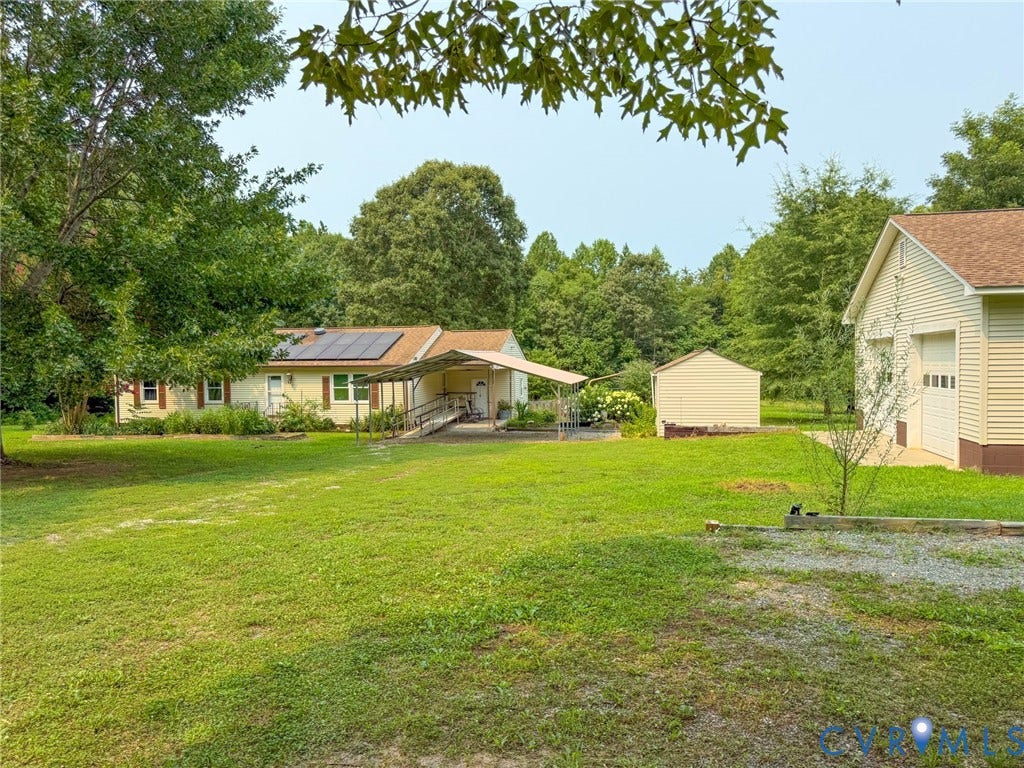 6688 Old Buckingham Road, Powhatan, VA 23139 Expansive outdoor space featuring a detached two-car garage, a separate storage shed, and mature tree landscaping