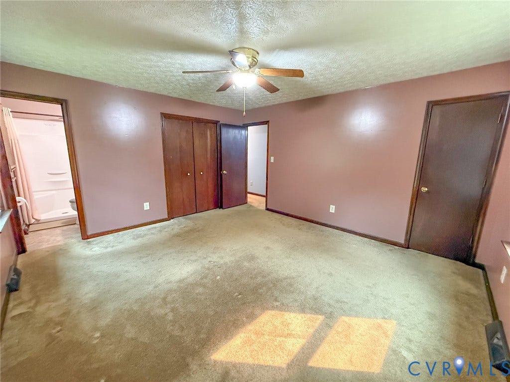 6688 Old Buckingham Road, Powhatan, VA 23139 Carpeted interior room featuring a ceiling fan with light fixture, wood-finish doors, and a partial view of a white shower stall