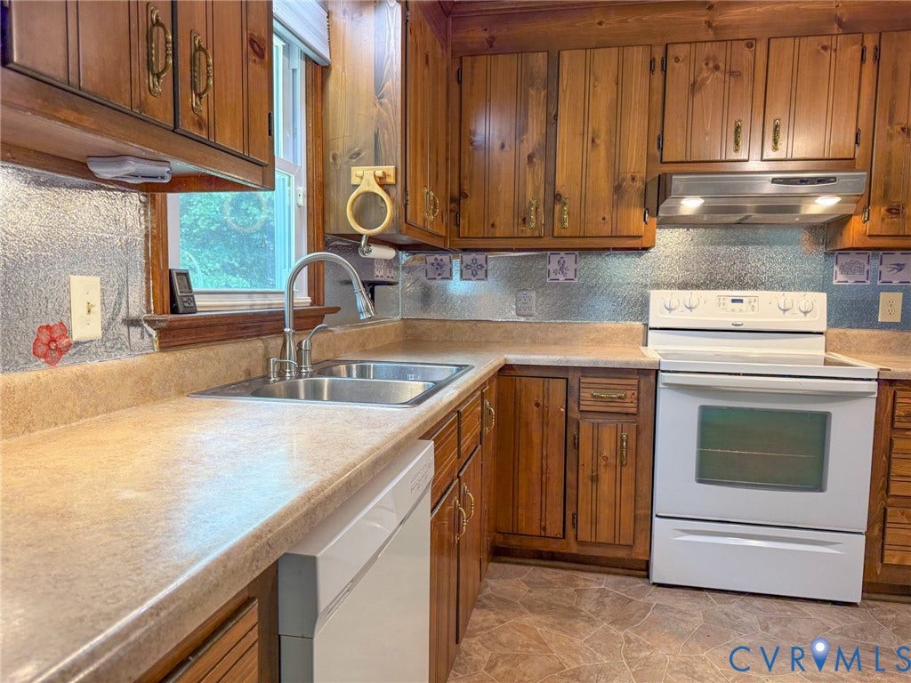 6688 Old Buckingham Road, Powhatan, VA 23139 Kitchen featuring wood cabinetry, laminate countertops, a double basin stainless steel sink with a gooseneck faucet, a white electric range, and a white dishwasher