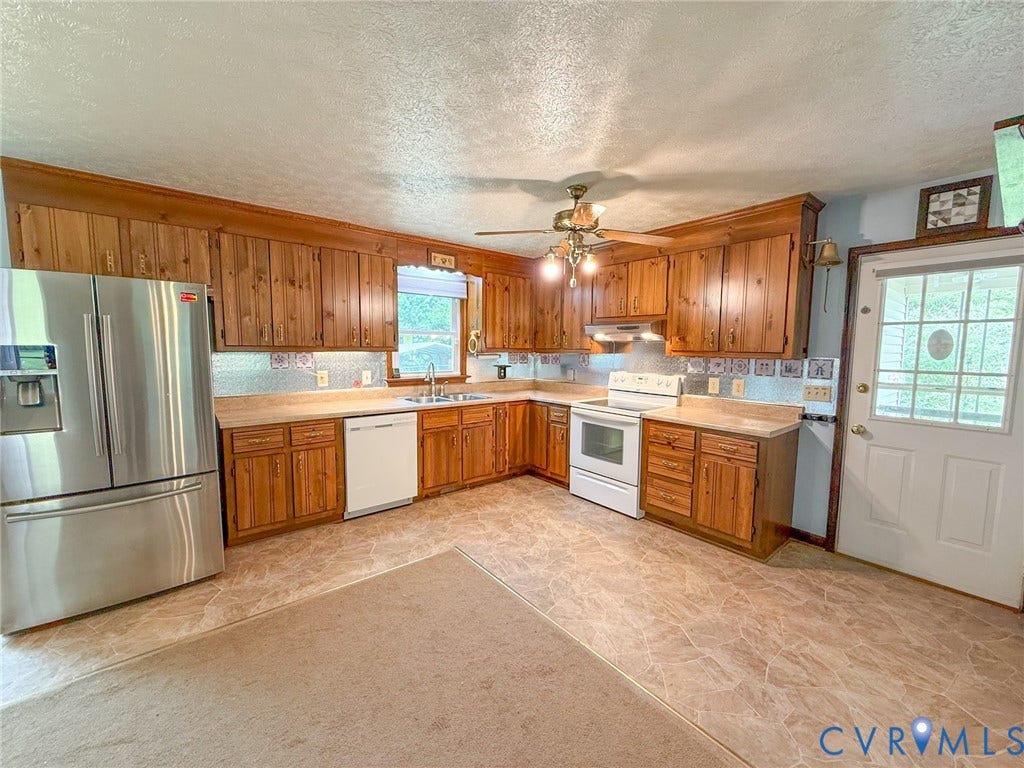 6688 Old Buckingham Road, Powhatan, VA 23139 Kitchen featuring extensive wood cabinetry, L-shaped countertops, stainless steel refrigerator, white dishwasher, and white electric range with a matching range hood