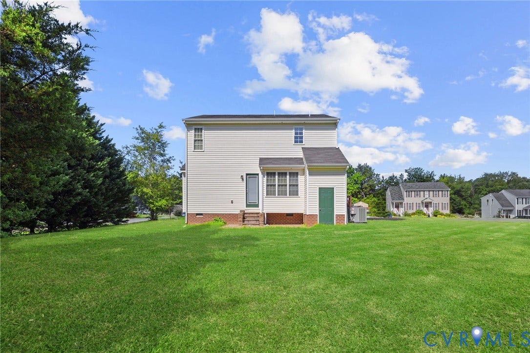 5025 Alberta Mews, Chesterfield, VA 23832 Spacious backyard featuring a large expanse of green lawn, mature perimeter trees, and a two-story home with light-colored siding. Virtually edited grass