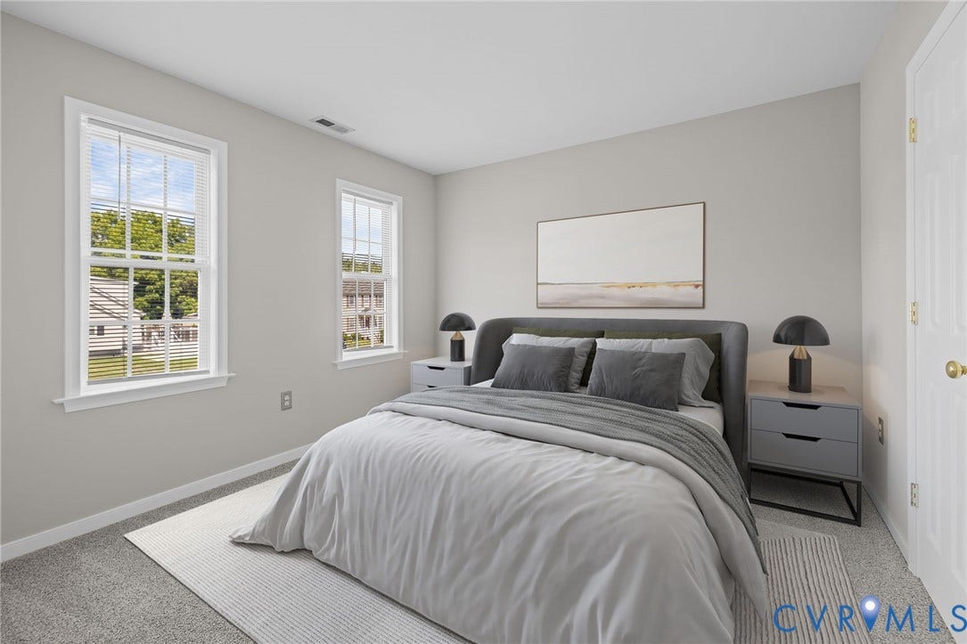 5025 Alberta Mews, Chesterfield, VA 23832 Carpeted room with two double-hung windows, a neutral wall color, and a white paneled door with a brass-finish knob. Virtually staged concept