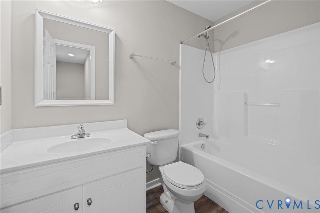 5025 Alberta Mews, Chesterfield, VA 23832 Bathroom featuring a white vanity with integrated sink, chrome faucet, framed mirror, and a full-size tub with shower kit