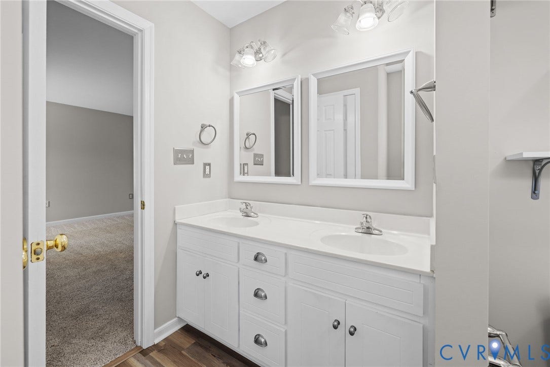 5025 Alberta Mews, Chesterfield, VA 23832 Bathroom vanity featuring dual sinks, white cabinetry with silver hardware, coordinating framed mirrors, and vanity lighting