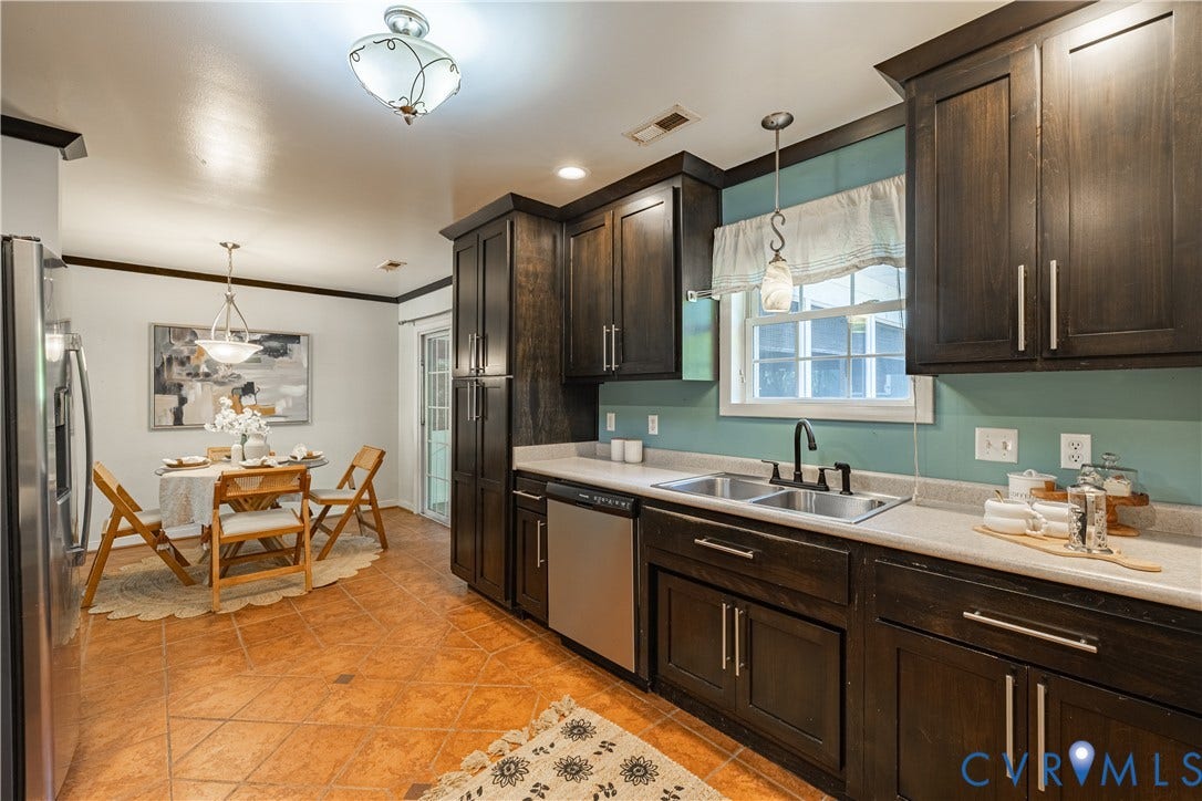 704 Forestview Drive, Colonial Heights, VA 23834 Kitchen featuring dark wood cabinetry, stainless steel sink, and light-colored countertops