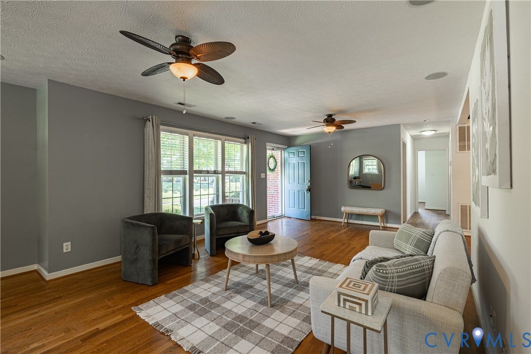 704 Forestview Drive, Colonial Heights, VA 23834 Living area with wood-finish flooring, two ceiling fans, and a light blue entry door